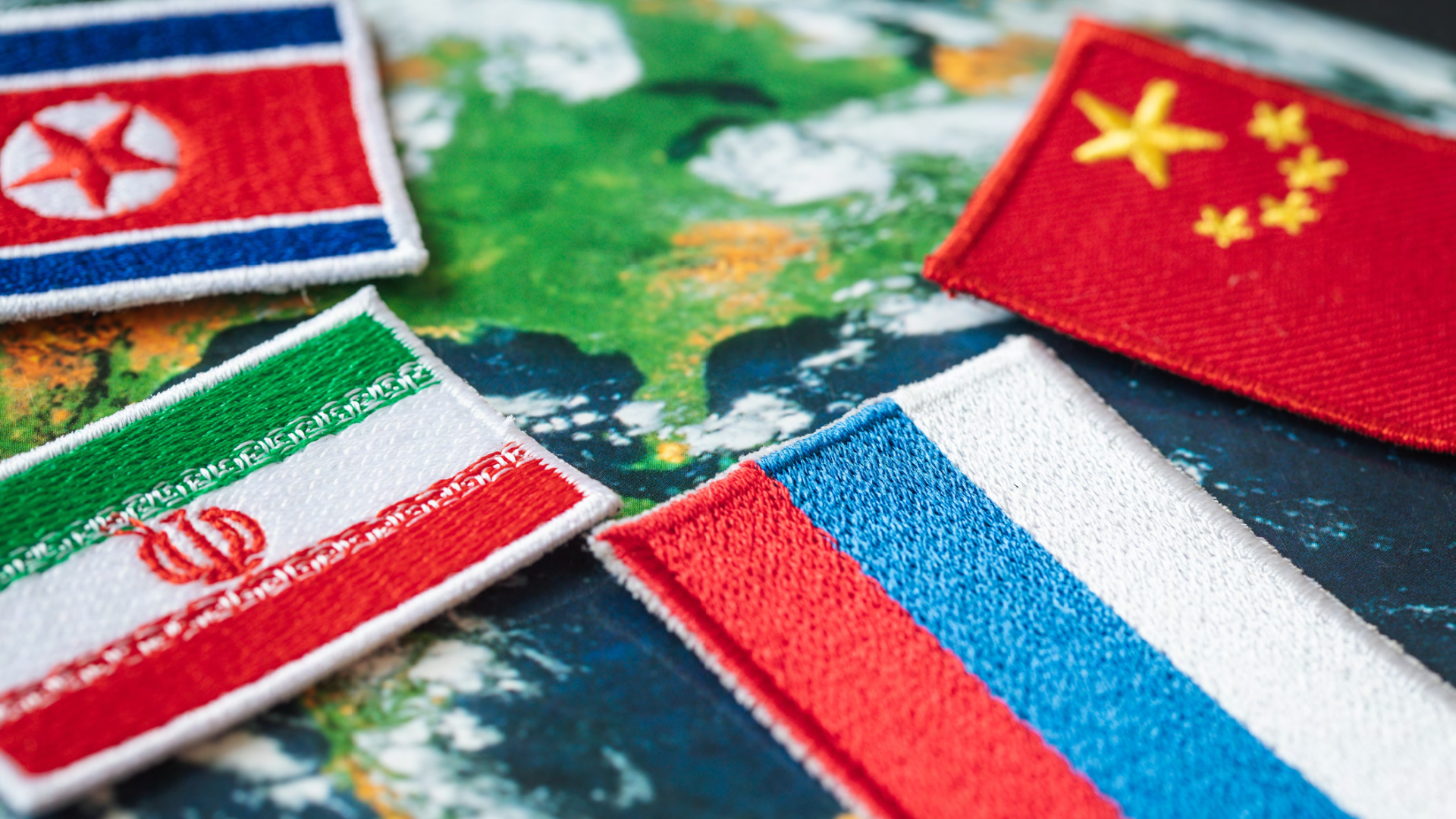 North Korea, China, Russia, and Iranian flags on top of a map.