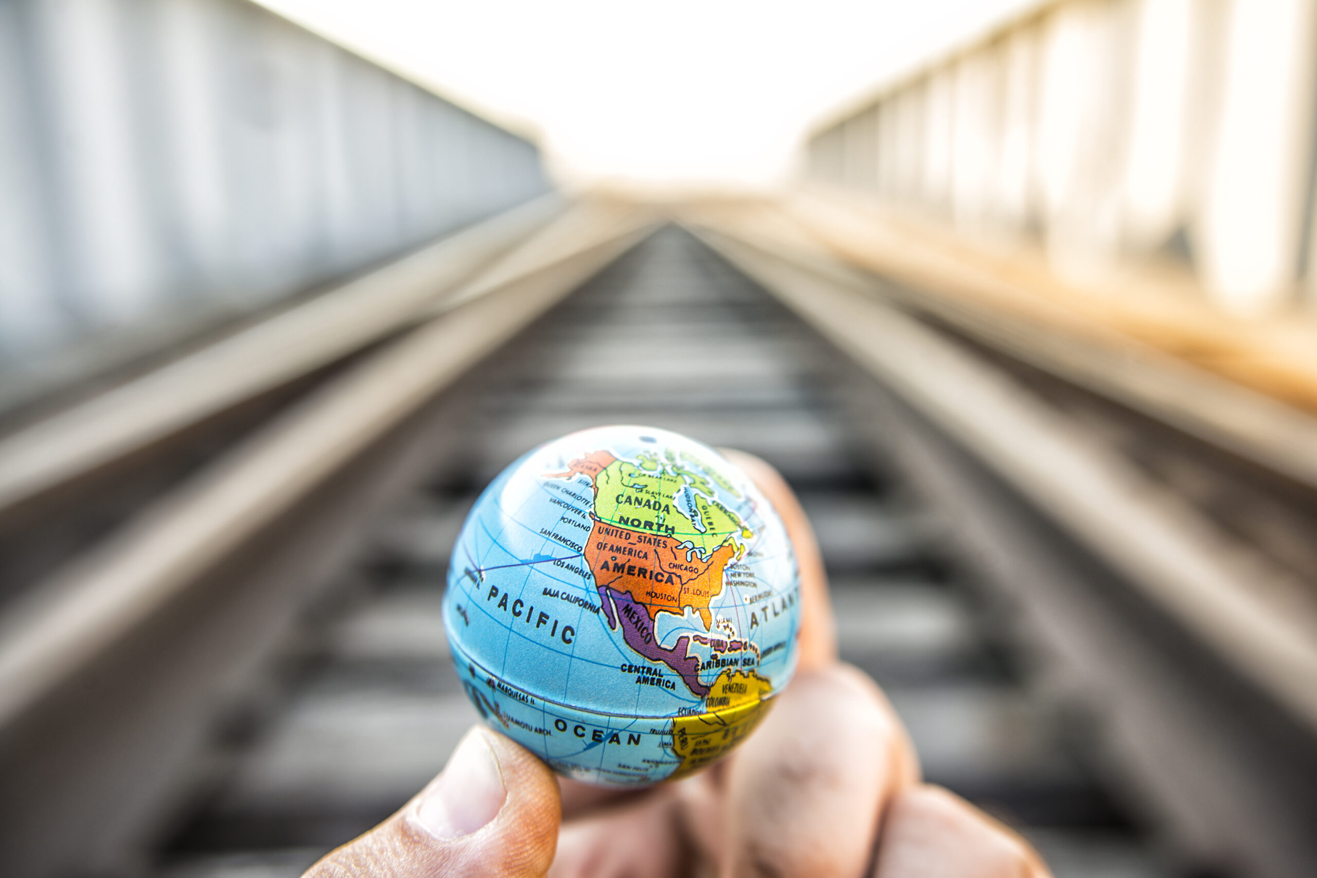 Hand holding a small globe.