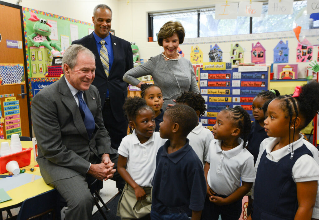 President and Mrs Bush in a school classroom with elementary age kids.