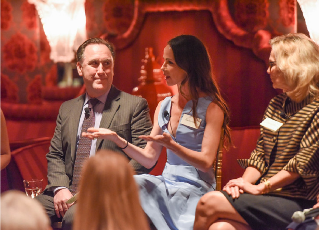 Barbara Bush speakign to a room full of people at a formal event.